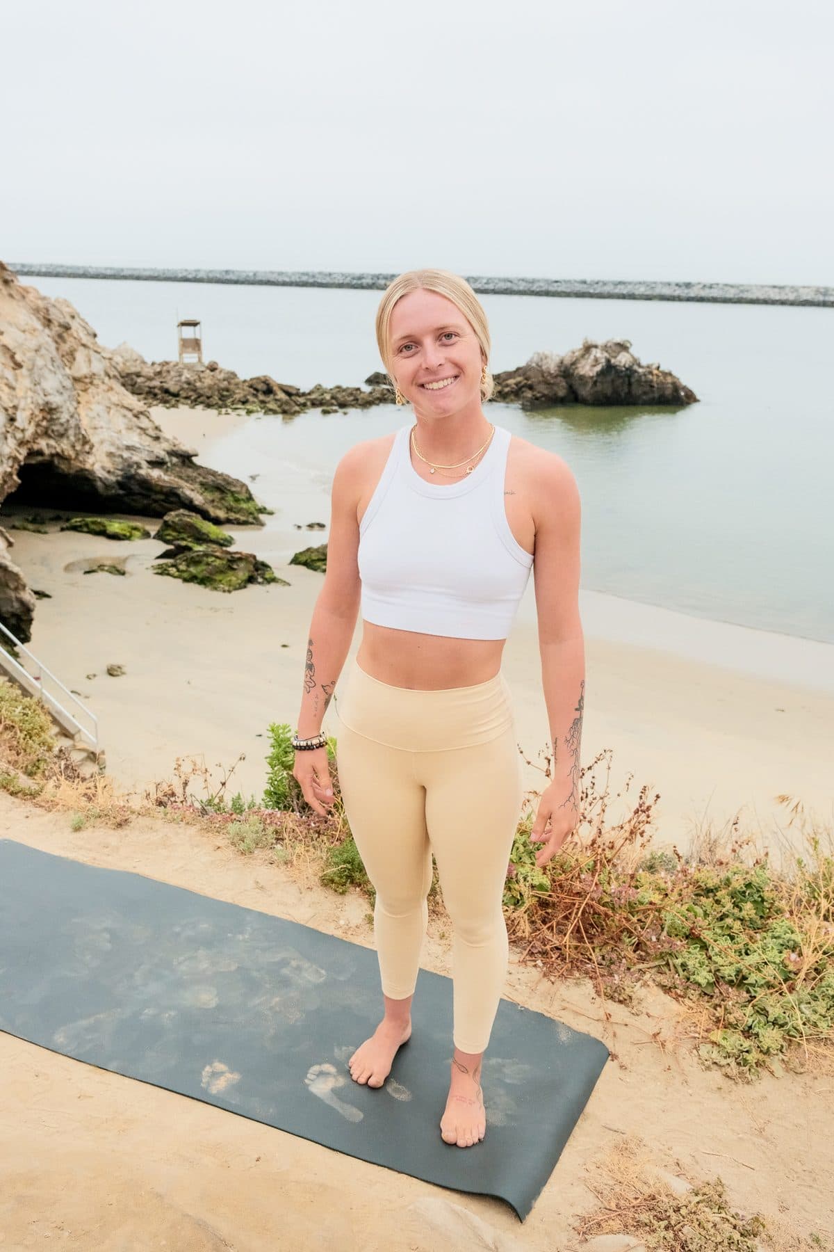 Coach Bella on a yoga mat at the beach